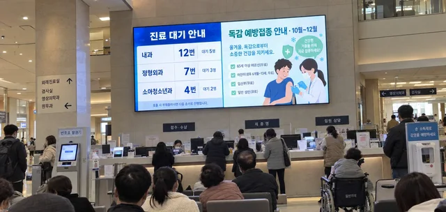 병원 로비 대기 공간 LED 화면에 진료 대기 순서와 예방접종 안내가 표시된 모습